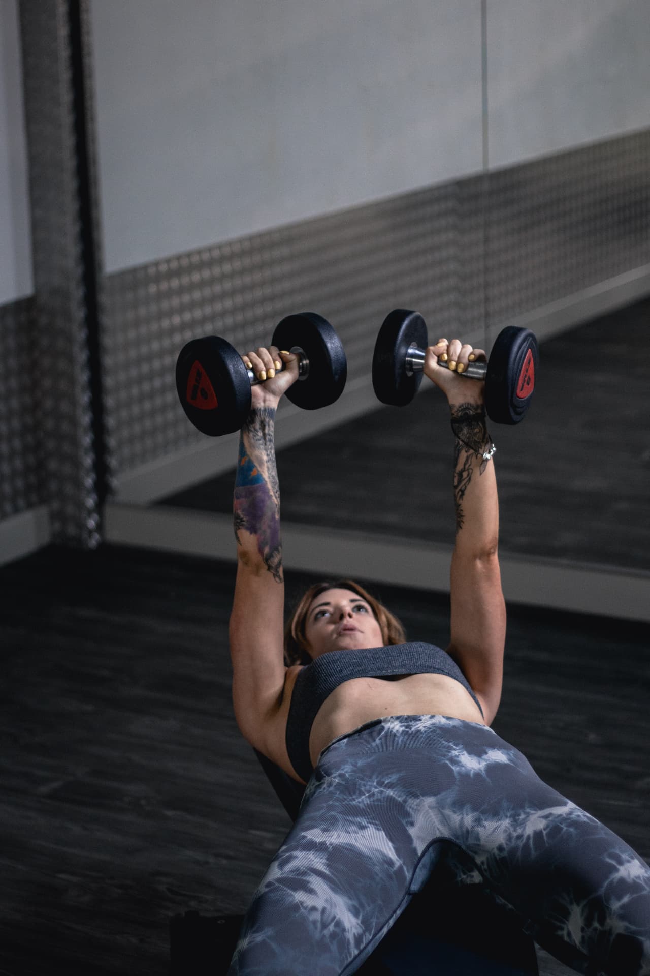 Coach pressing dumbbells during an HRC Coaching exercise library shoot