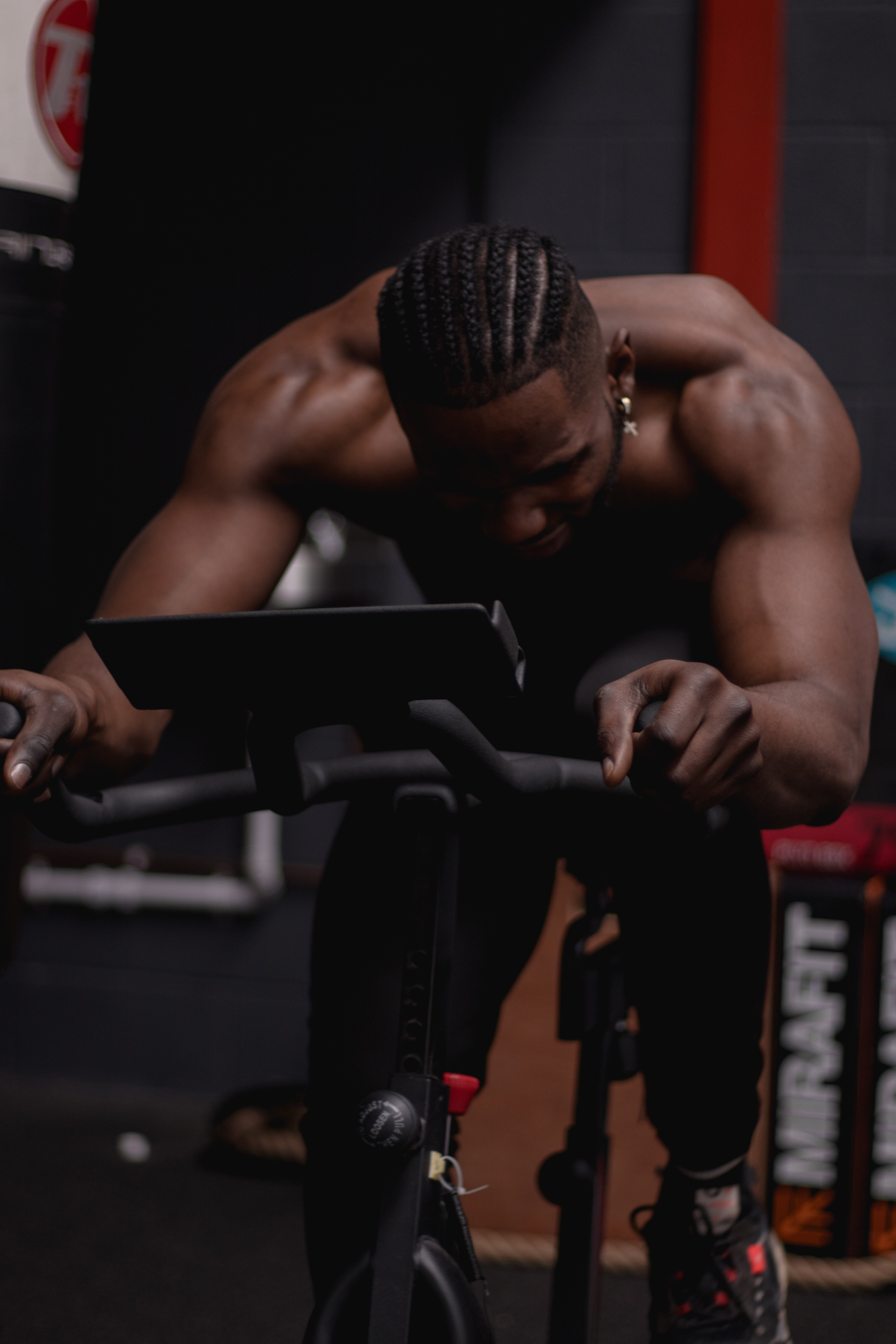 Close-up of an athlete driving hard on the spin bike