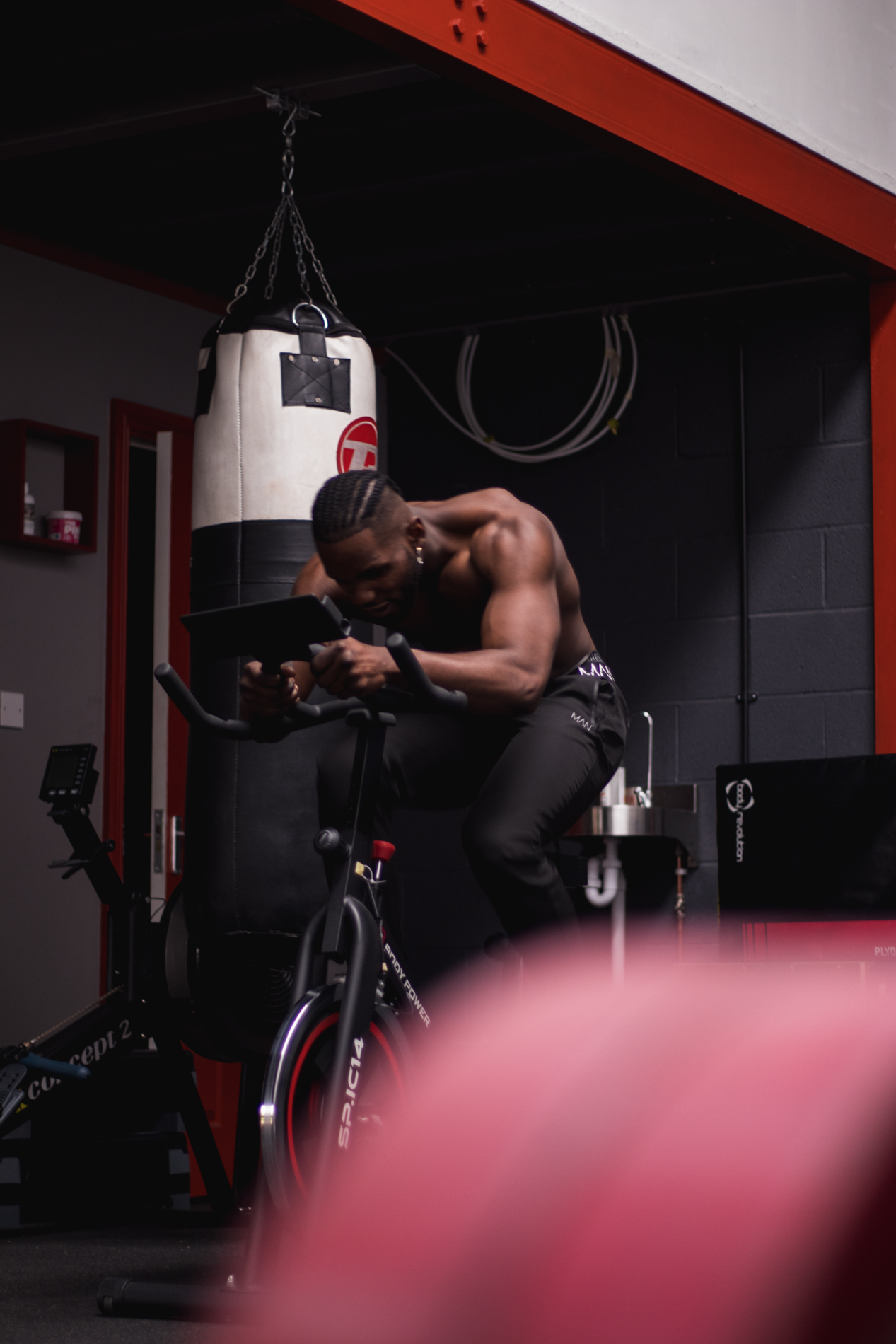 Athlete training on the bike beside a punch bag