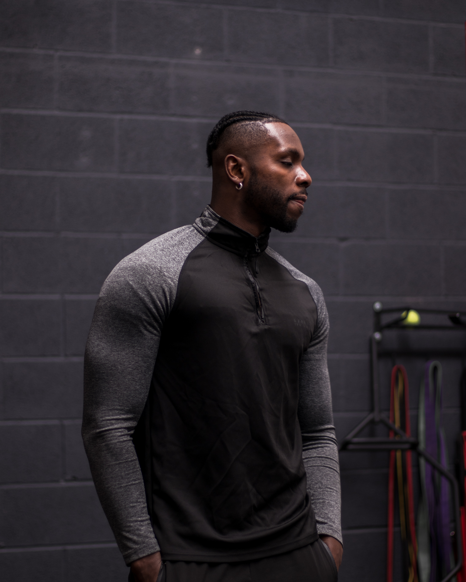 Side profile portrait of the athlete against a dark gym wall