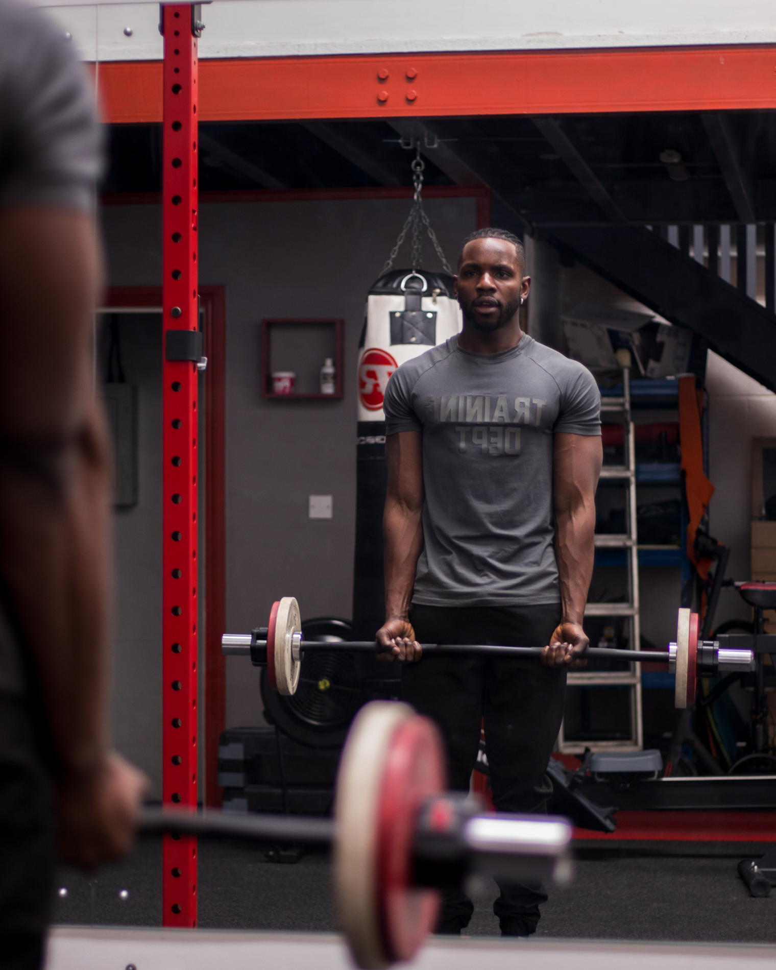 Athlete holding a loaded barbell in front of the mirror
