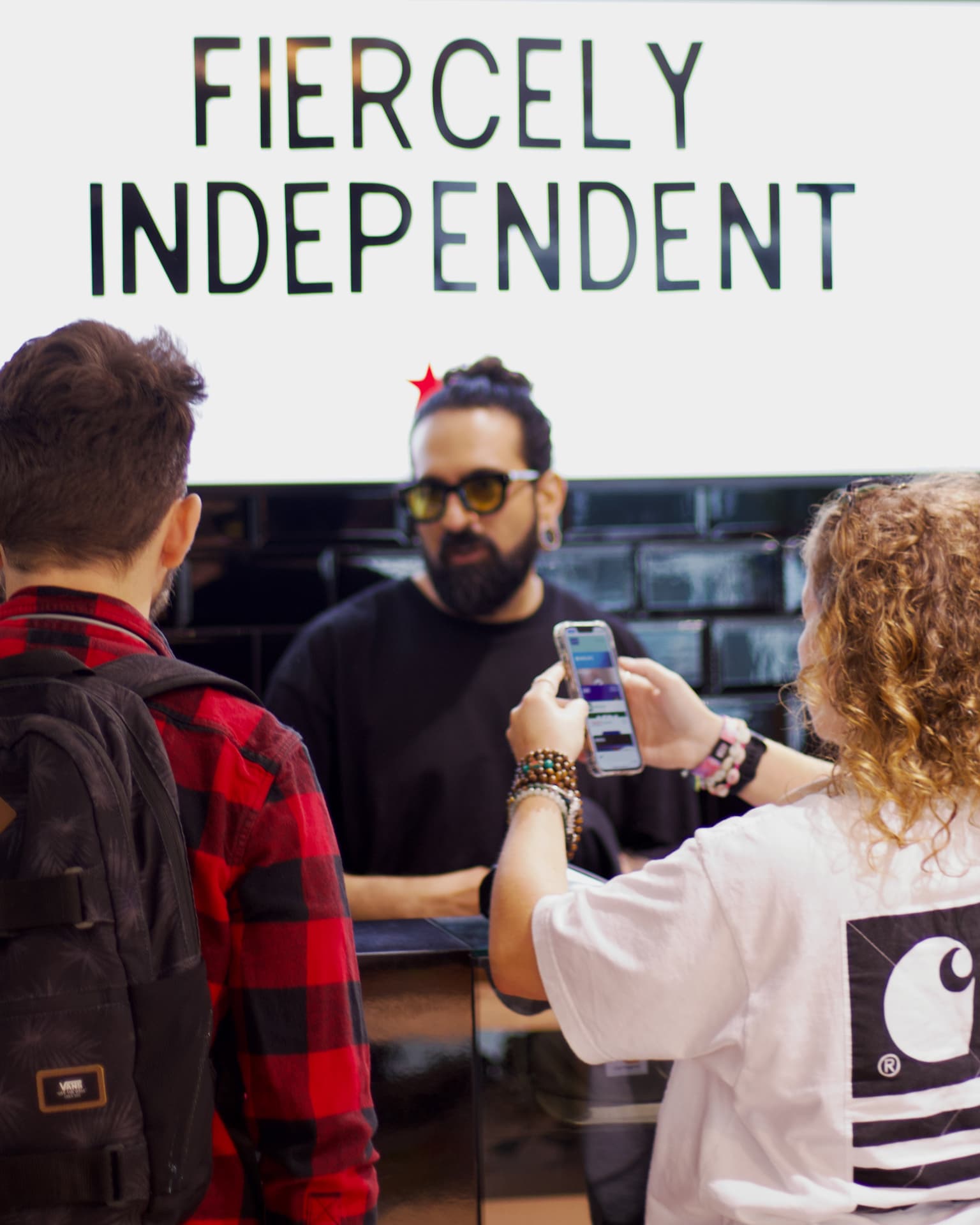 Customers at the counter under the Fiercely Independent sign